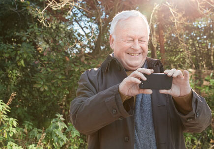 Man taking a photo on his phone in the countryside Man taking a photo on his phone in the countryside