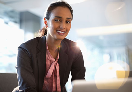 woman smiling leaning over desk woman smiling leaning over desk