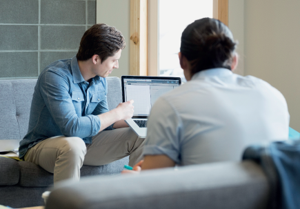 Two men looking at a screen on a laptop Two men looking at a screen on a laptop
