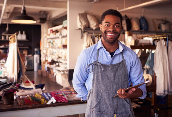 Shop worker smiling at the camera holding a tablet