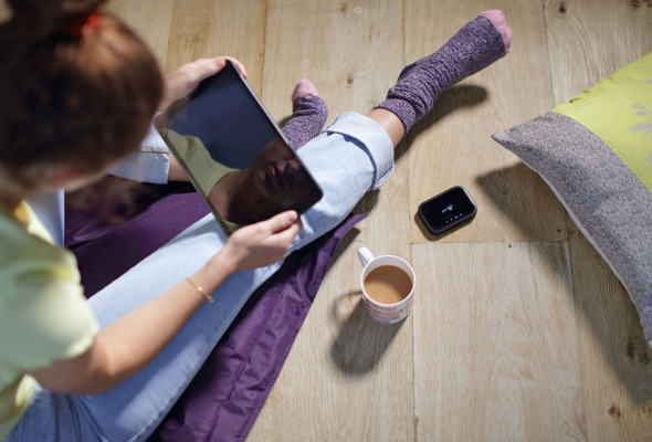 Woman sat on floor using a tablet