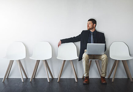 Man sat on a chair with empty seats surrounding him Man sat on a chair with empty seats surrounding him