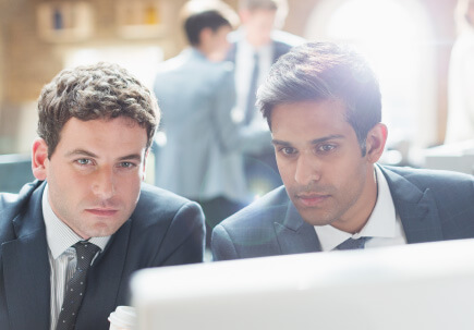 Two men talking over a screen