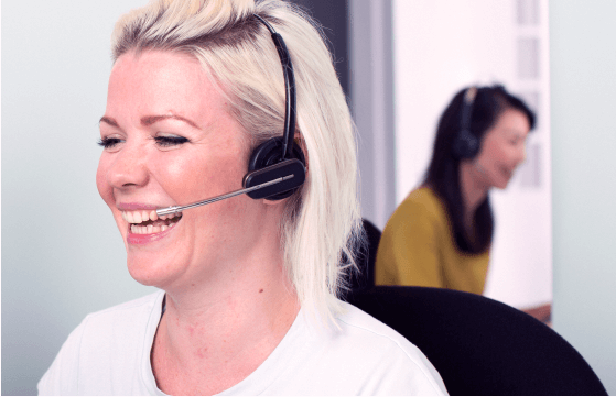Two women laughing through their headsets Two women laughing through their headsets